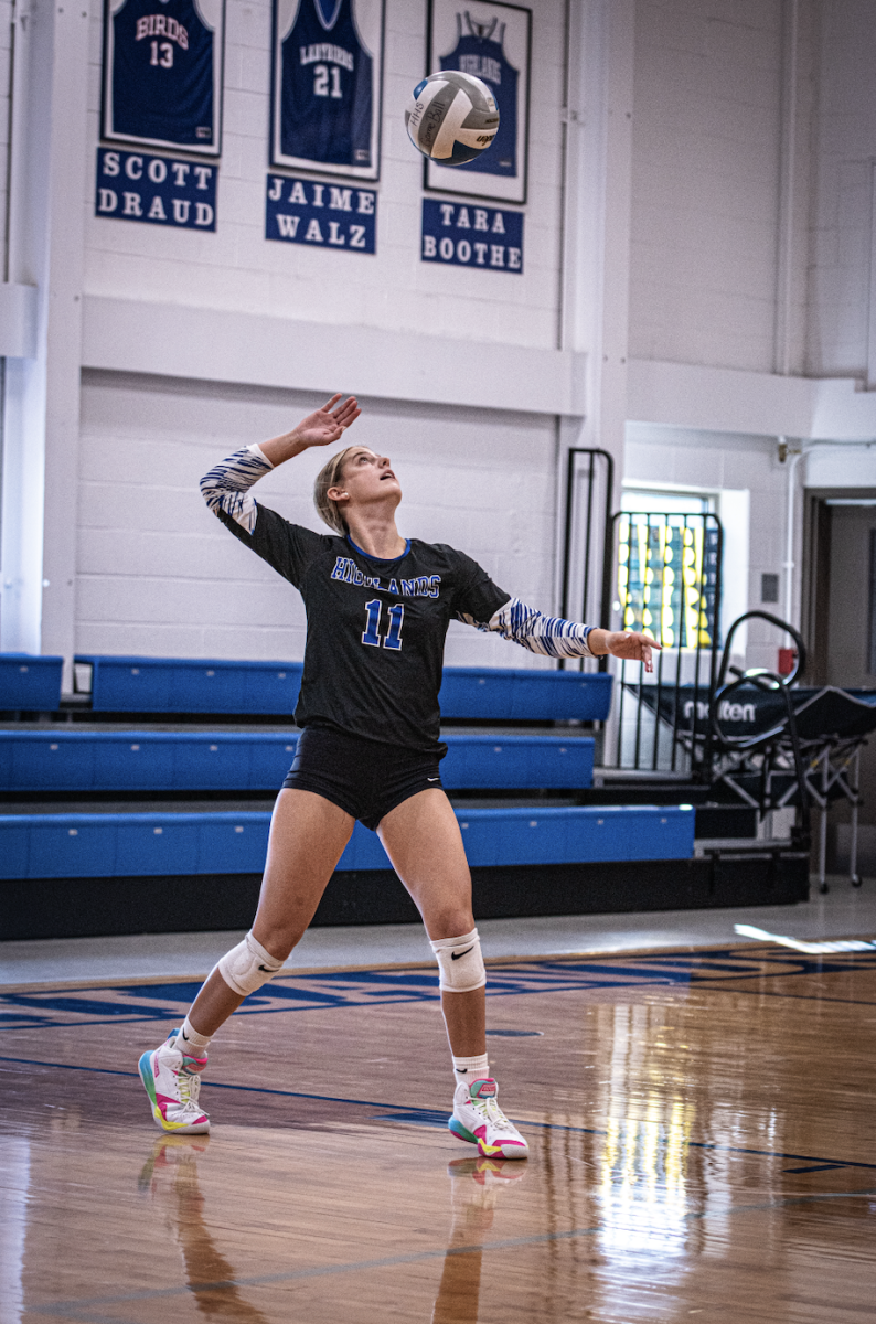 Ellie Mohr (12) serves the ball over the net. 